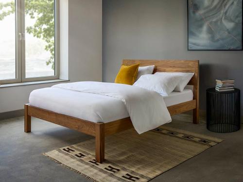 Luxury white bedding set with duvet cover and pillowcases on minimalist wooden bed, premium cotton bedding for modern bedroom decor.