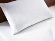 Hollowfiber pillow against a solid walnut wood headboard