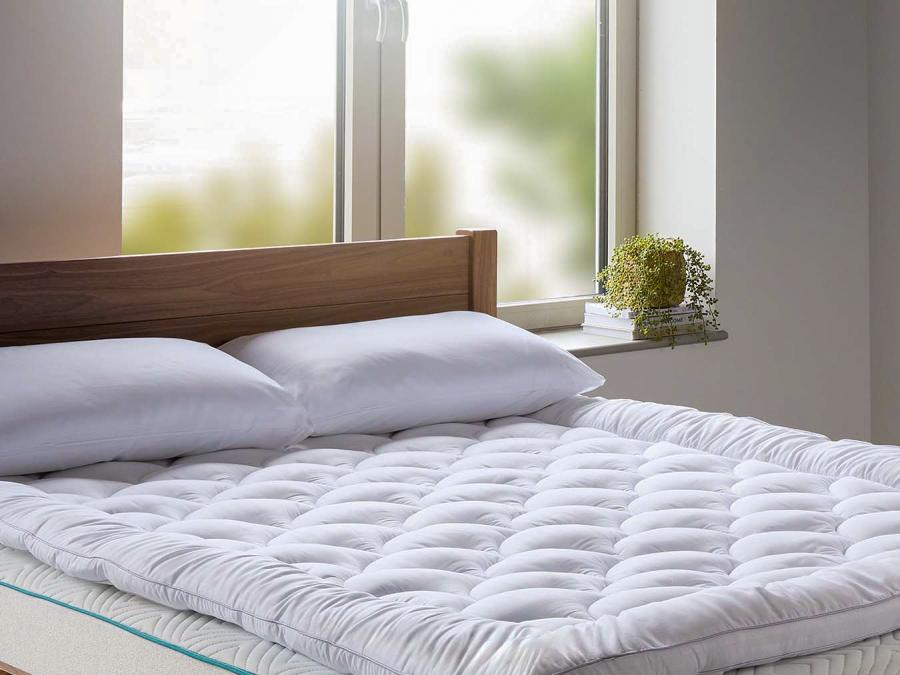 Thick 5cm mattress topper on-top of a large solid walnut wooden bed