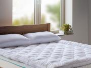 Thick 5cm mattress topper on-top of a large solid walnut wooden bed