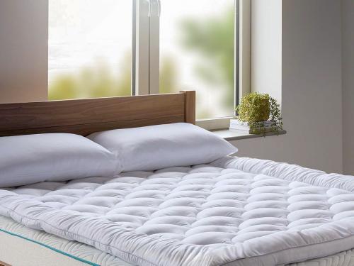 Thick 5cm mattress topper on-top of a large solid walnut wooden bed