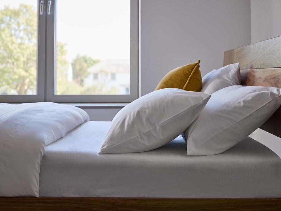 Soft bedding on wooden bed